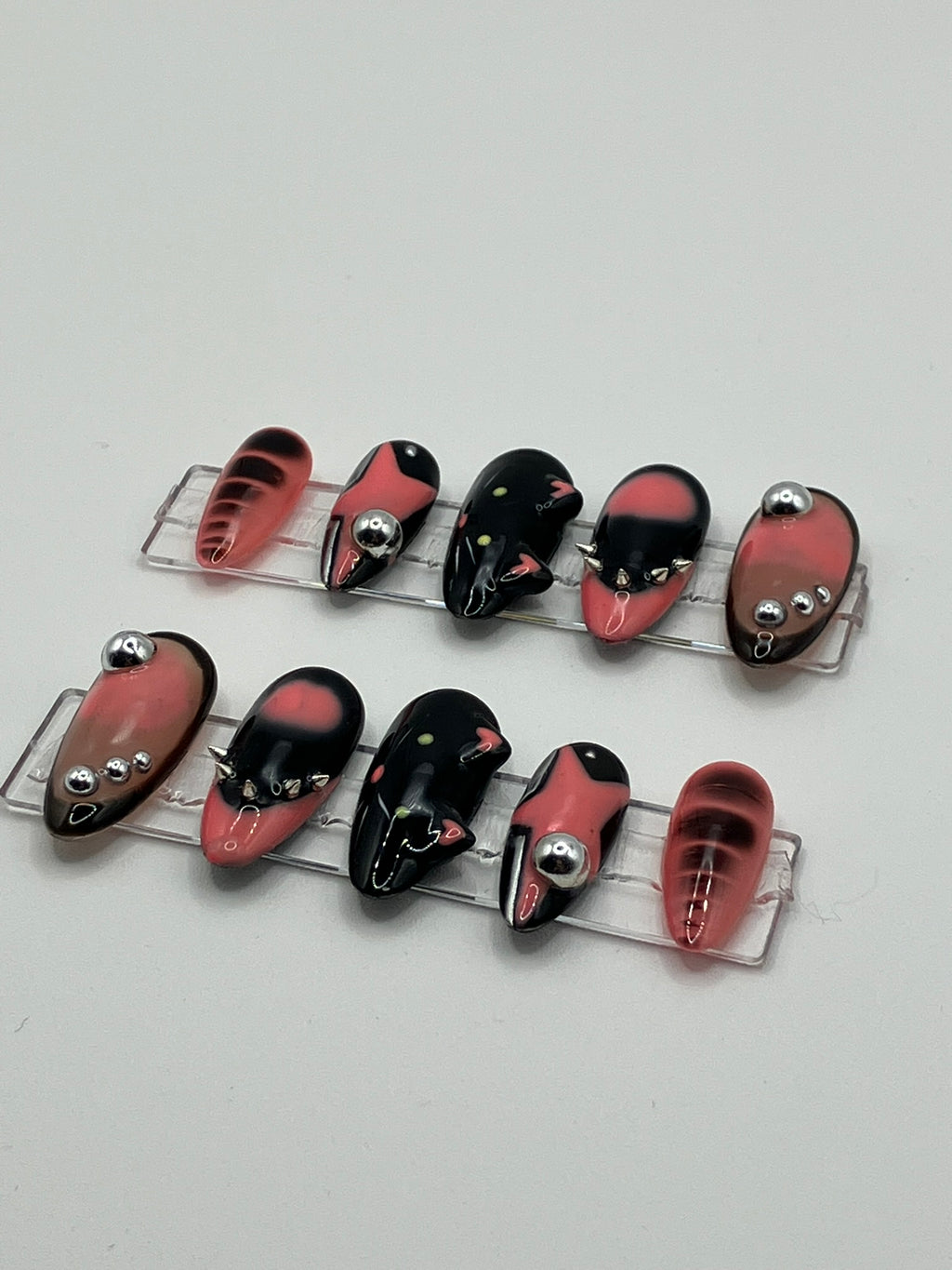 Set of pink and black press-ons on a white background