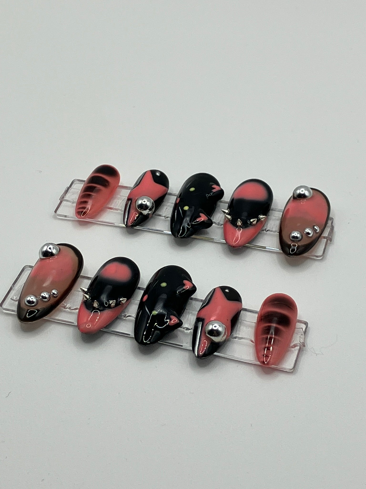 Set of pink and black press-ons on a white background